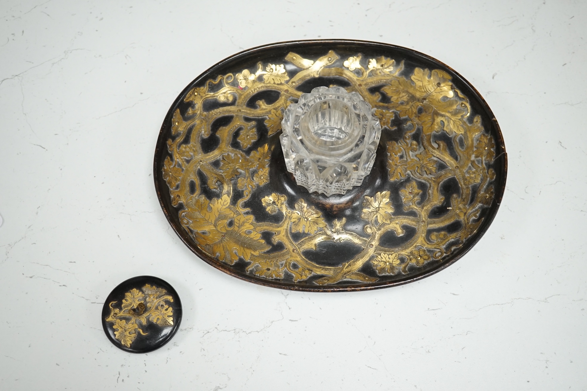 A Victorian ebonised and brass overlaid inkstand with cut glass ink well, 27cm wide. Condition - poor